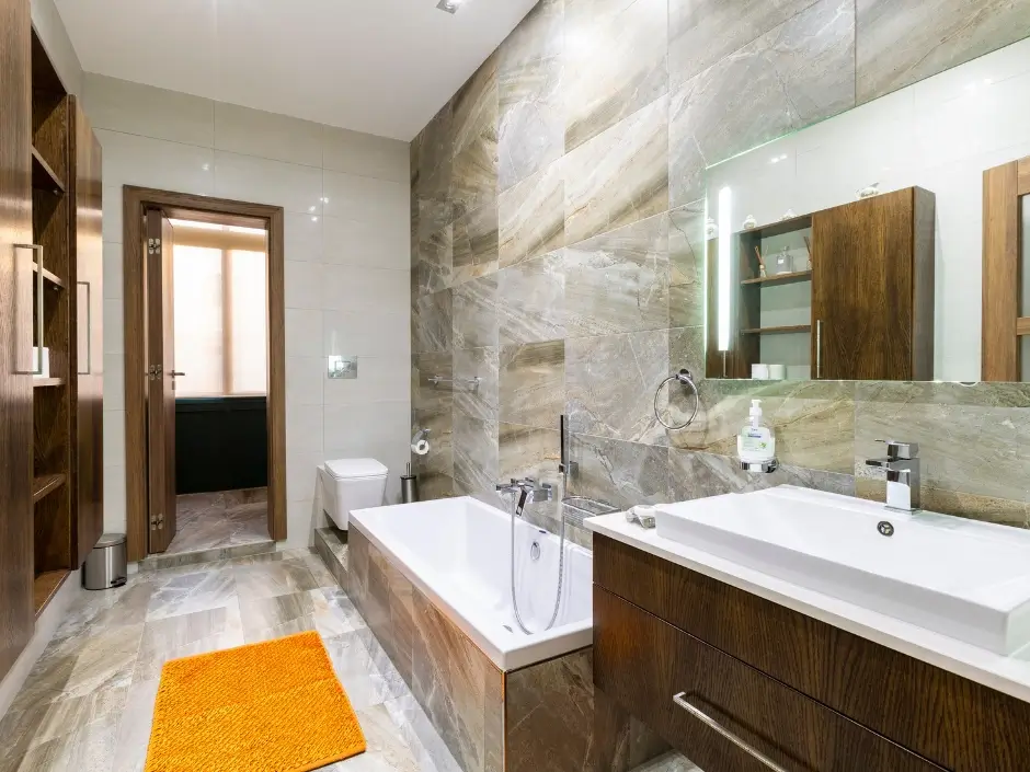 Modern bathroom with wooden cabinets, a bathtub, and elegant tile design, showcasing professional property management services in Malta