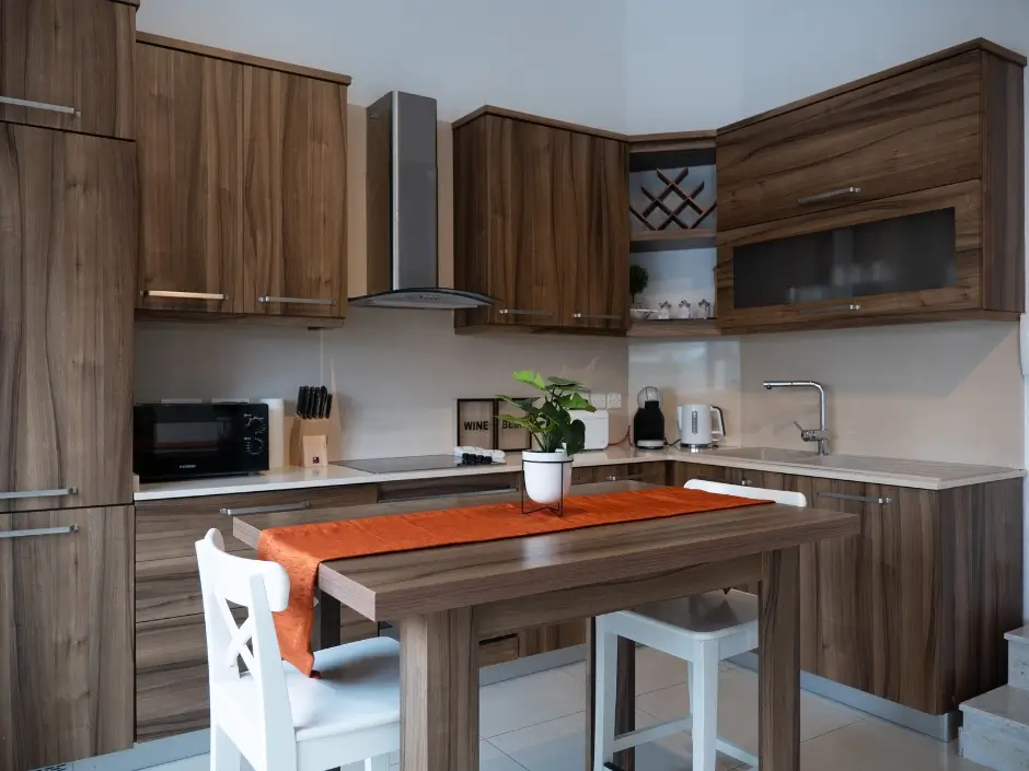 Stylish kitchen with wooden cabinets, orange table runner, and modern appliances, showcasing managed rental properties in Malta