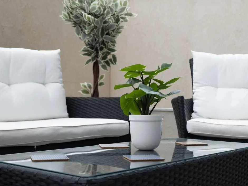 Comfortable outdoor seating with white cushions, glass table, and greenery, ideal for short-term rental properties in Malta